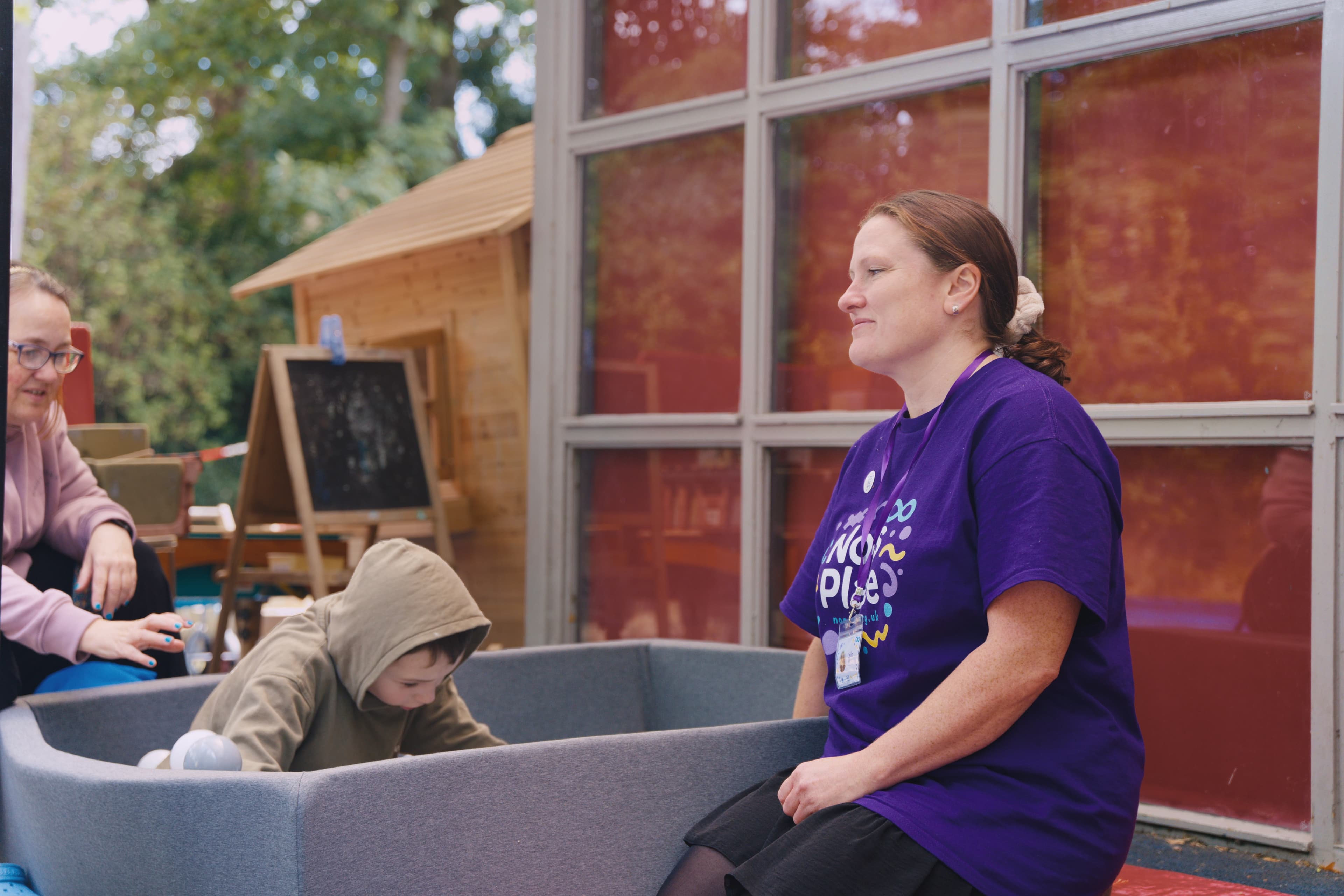 A team member sitting with a child in a calm sensory play area
