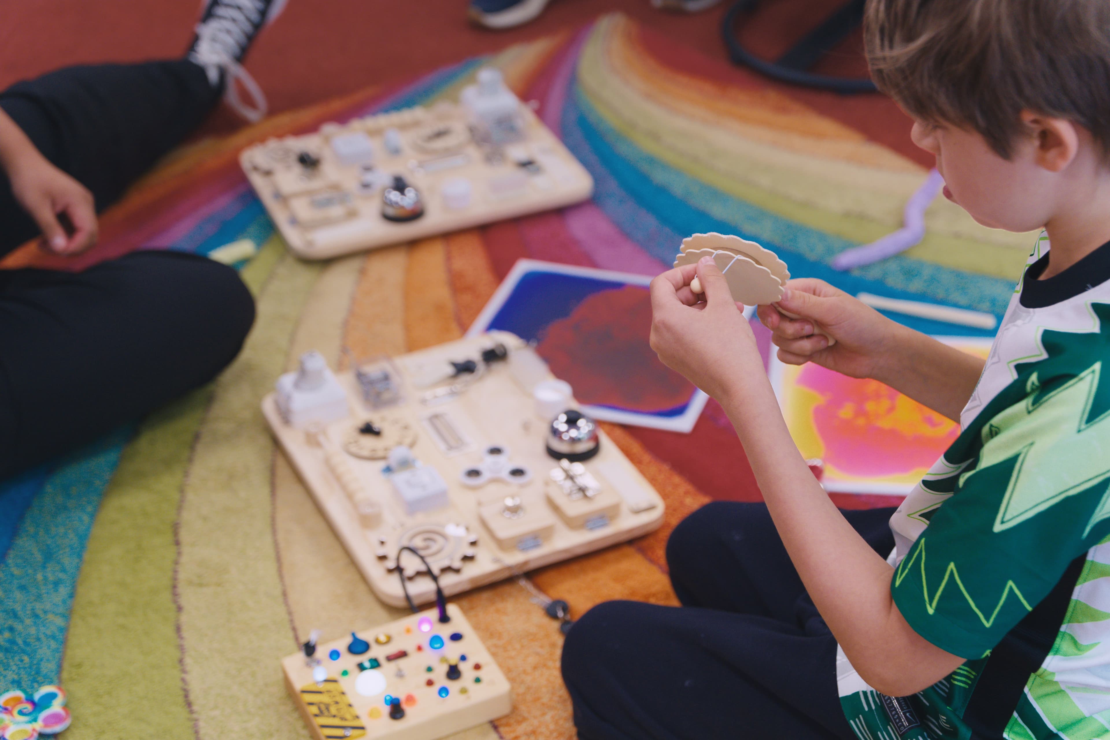A child exploring sensory busy boards and switches