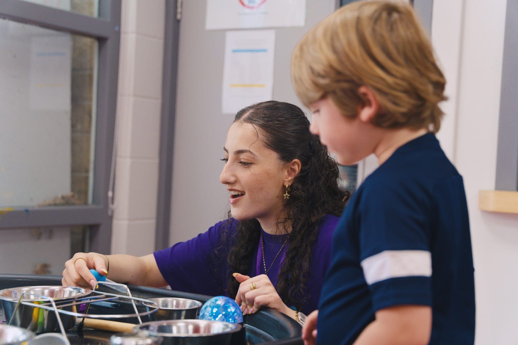 A Noa's Place team member supporting a child during sensory water play