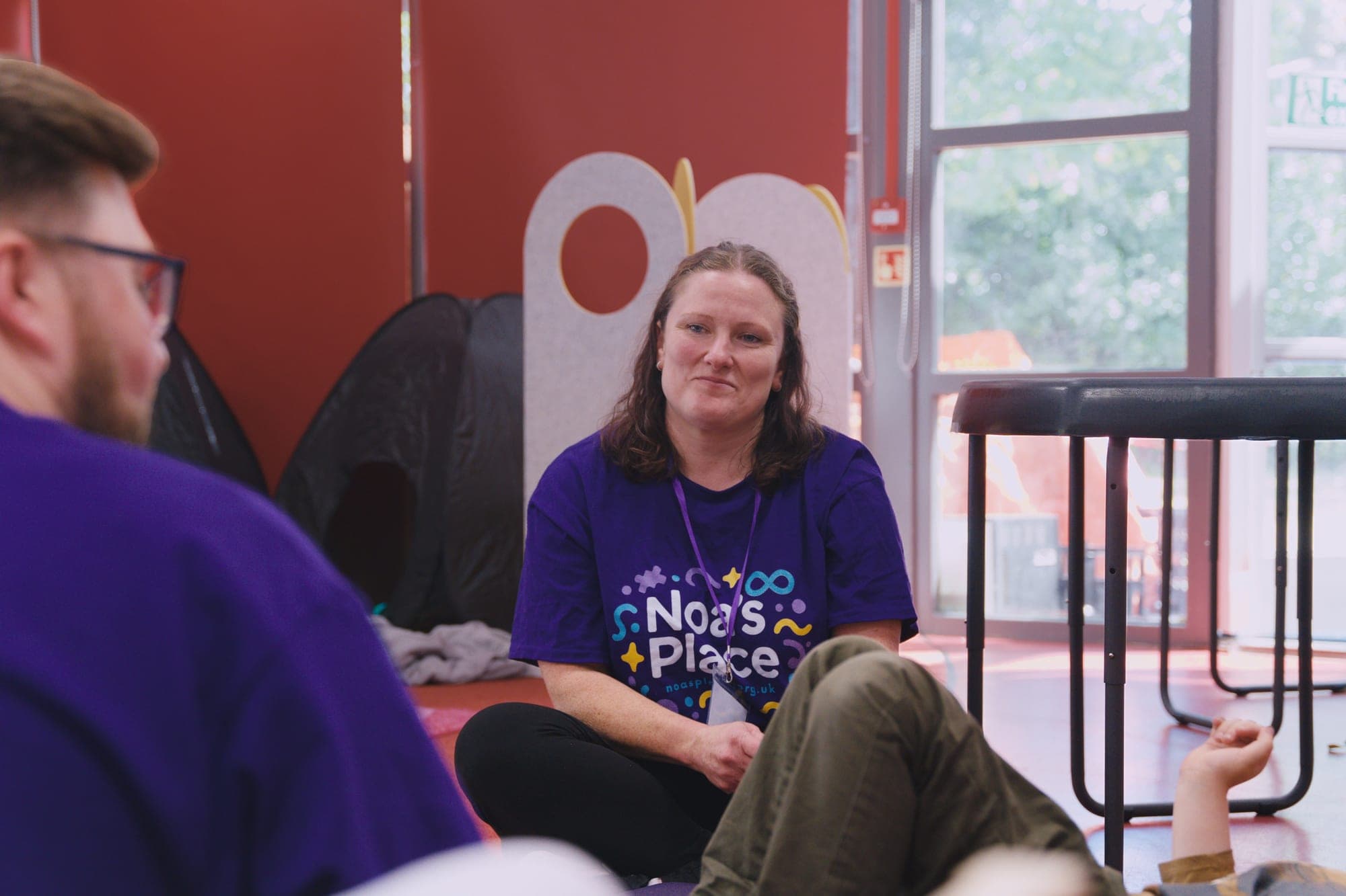 Staff and a volunteer sitting together in a calm, welcoming space